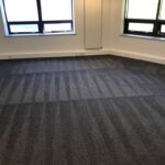 This is a photo of a grey office carpet that has just been professionally steam cleaned works carried out by Mile End Carpet Cleaning