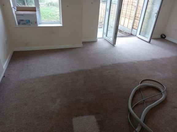 This is a photo of an empty living room with a brown carpet that is in the process of having its carpets steam cleaned works carried out by Mile End Carpet Cleaning